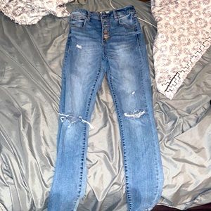 Medium-wash high rise straight leg jeans with rips at the knees